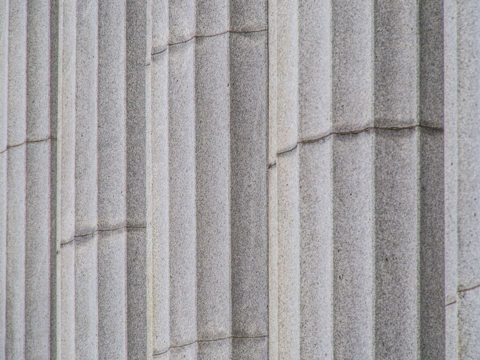 Stone columns of a classical building, in black and white